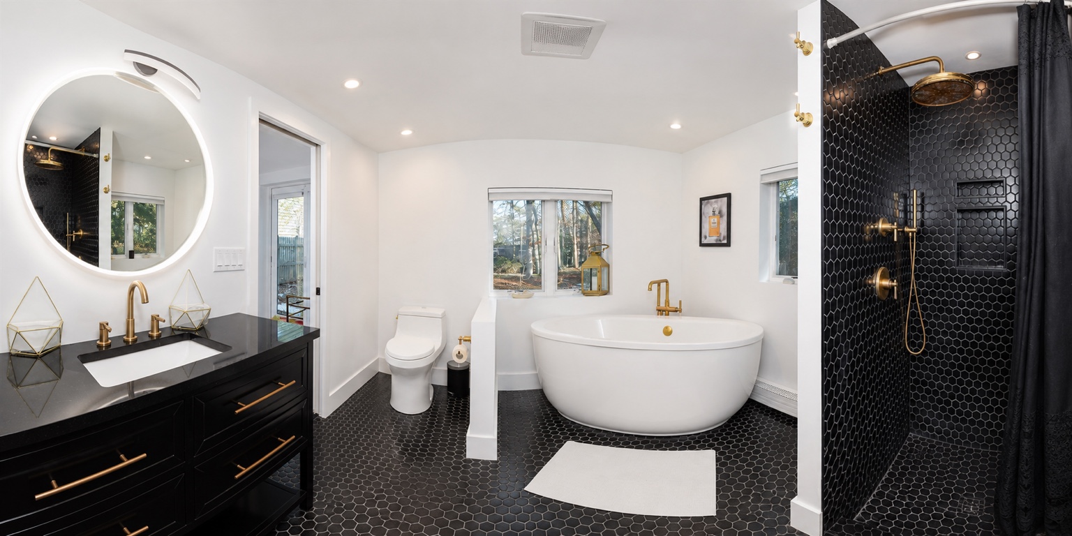 Primary bathroom with spa tub, custom vanity, and walk-in tiled shower.